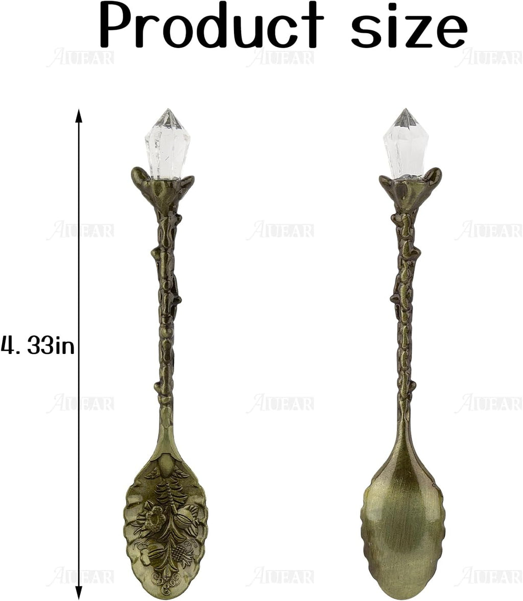 Two decorative spoons with crystal tops and measurements on a white background