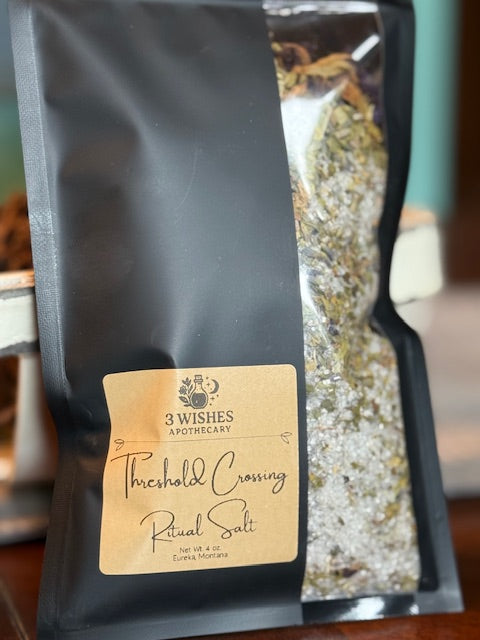 Black package of 'Threshold Crossing Ritual Salt' by 3 Wishes Apothecary with blurred background.